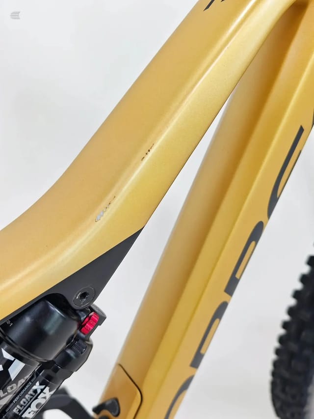 Yellow hardtail mountain bike frame, non-drive side, angled upward against white background. Shows seat tube, chain stays, and black decals.